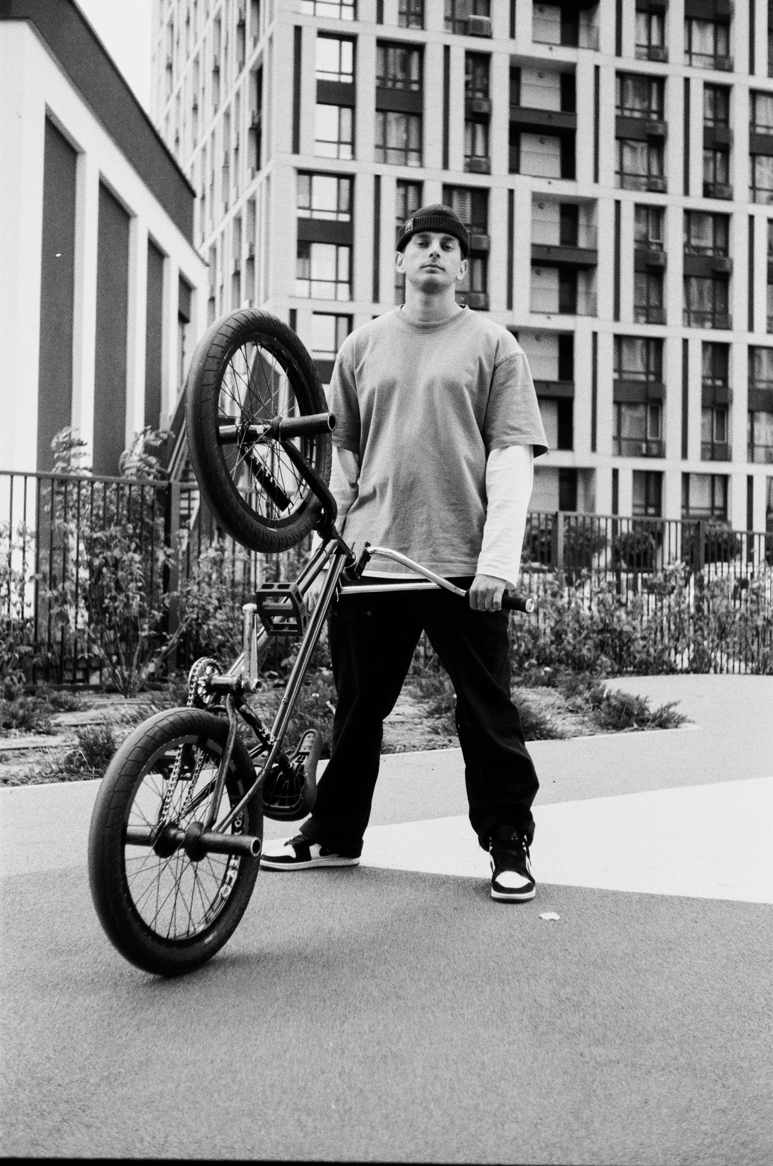 man standing next to a parked motorcycle outside