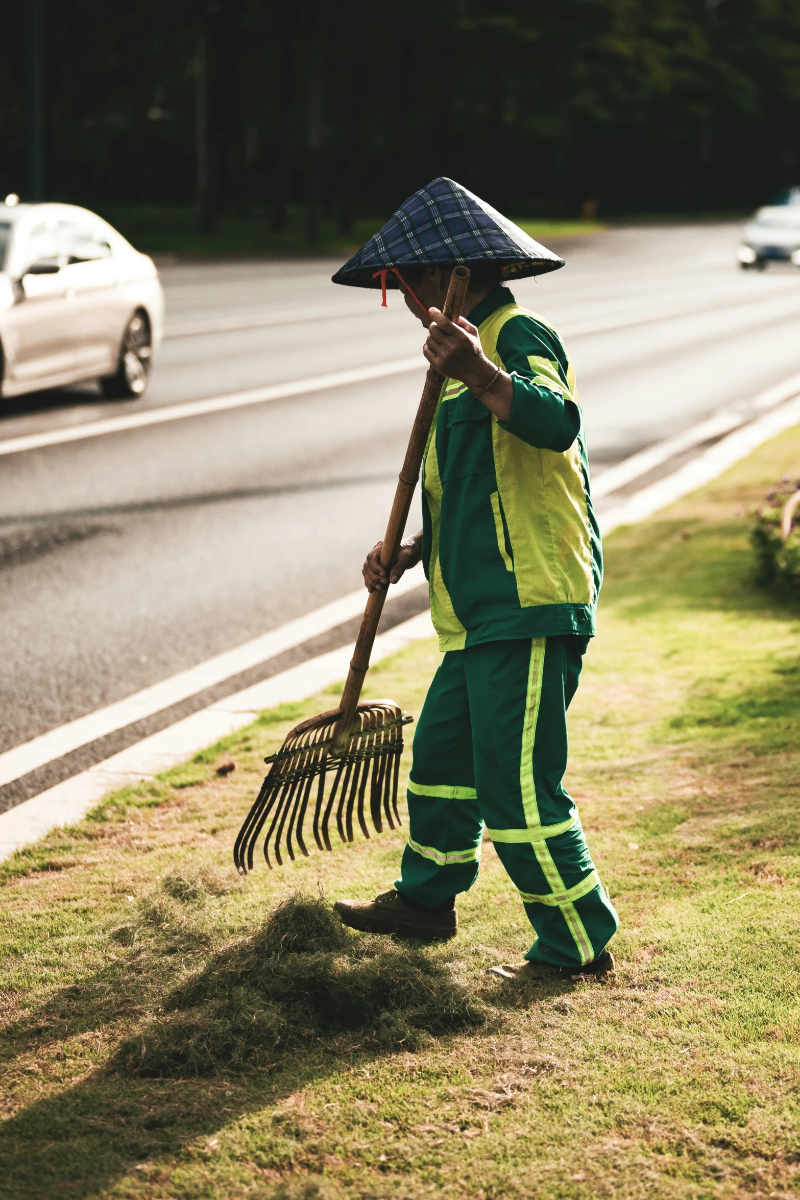 a person in green clothing carrying a hoe