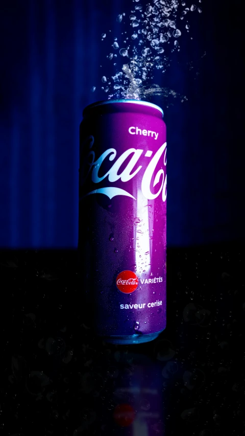 a can of coca - cola is spilling and splashing water