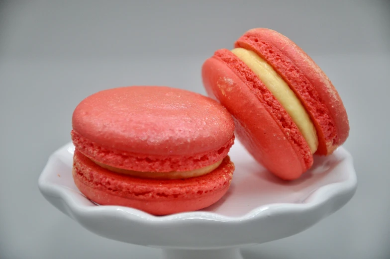 two macaroons sitting on a plate on top of a table