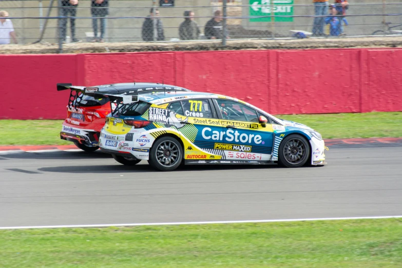 a car driving around a track near a crowd