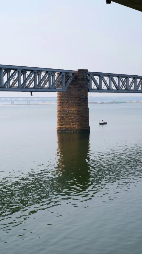 a man riding on the back of a boat near a bridge