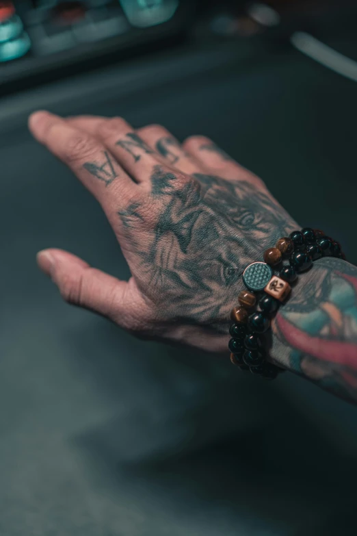 a tattooed hand holding soing on top of it