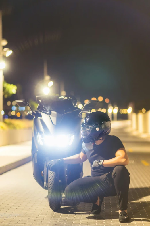 a man sitting on the ground with a motorcycle next to him