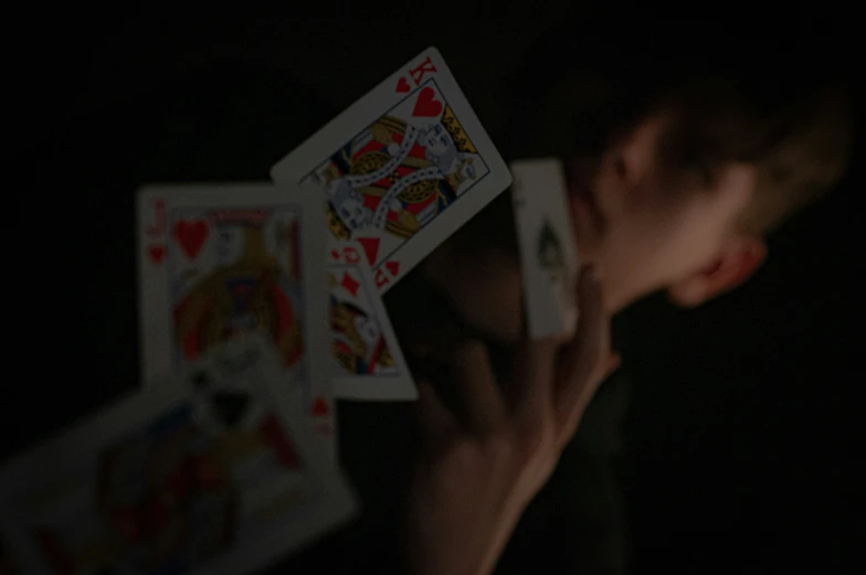 a person is holding cards in the dark