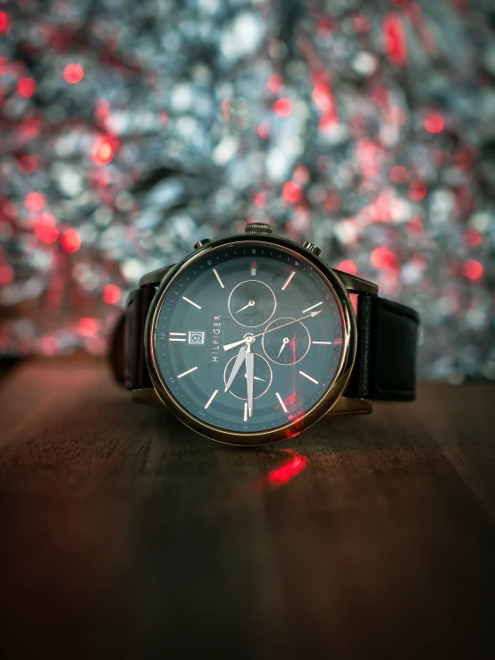 a watch with a black leather band, red light and white numbers