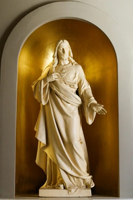 a large white statue that is near some golden wall