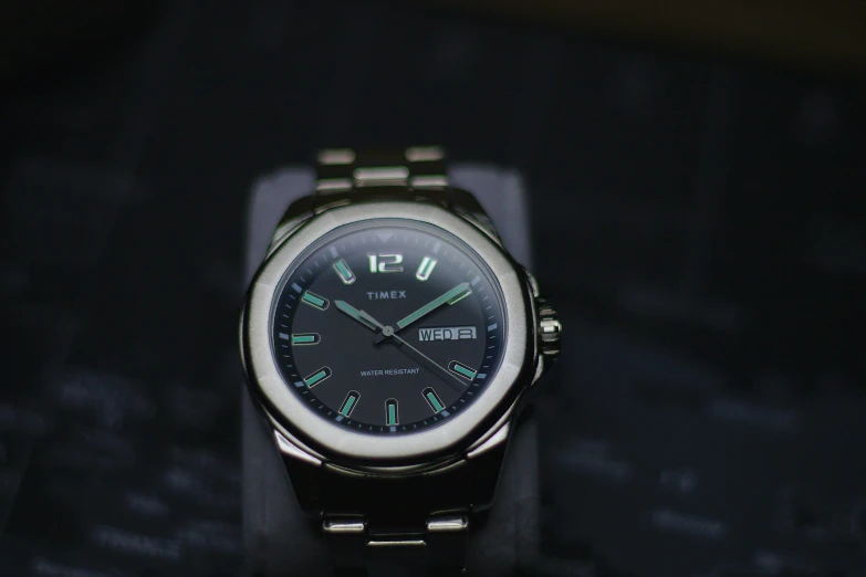 a black and silver watch sitting on top of a table