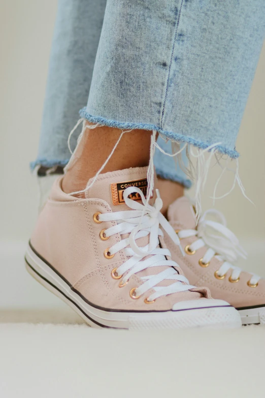 a person is wearing pink sneakers and jeans
