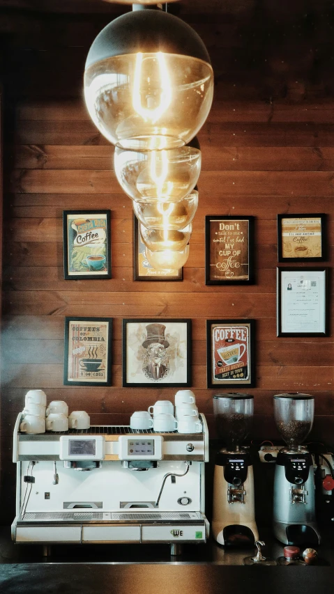 an espresso machine next to framed pictures and a lamp