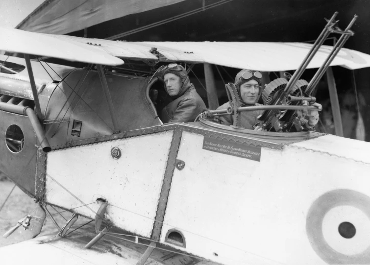 an old time po of some men sitting in a small airplane