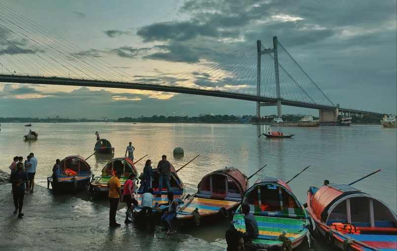 the boats are on the shore by the bridge