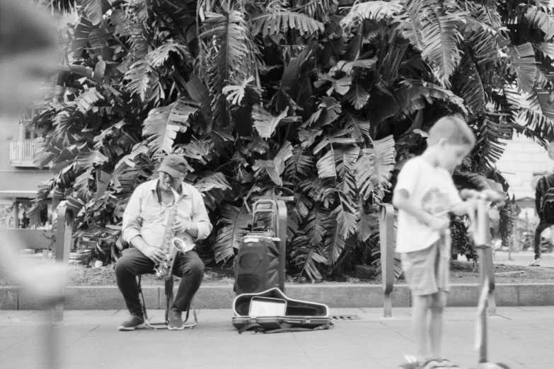 black and white pograph of two men sitting on the street