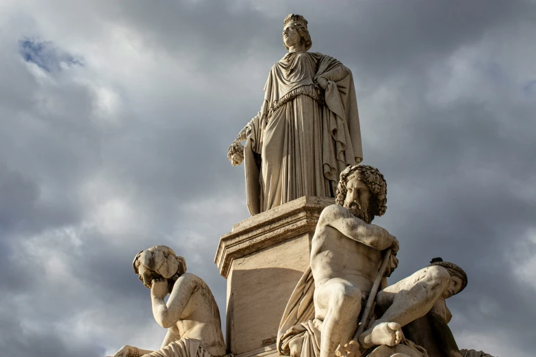 three sculptures sitting below a cloudy blue sky