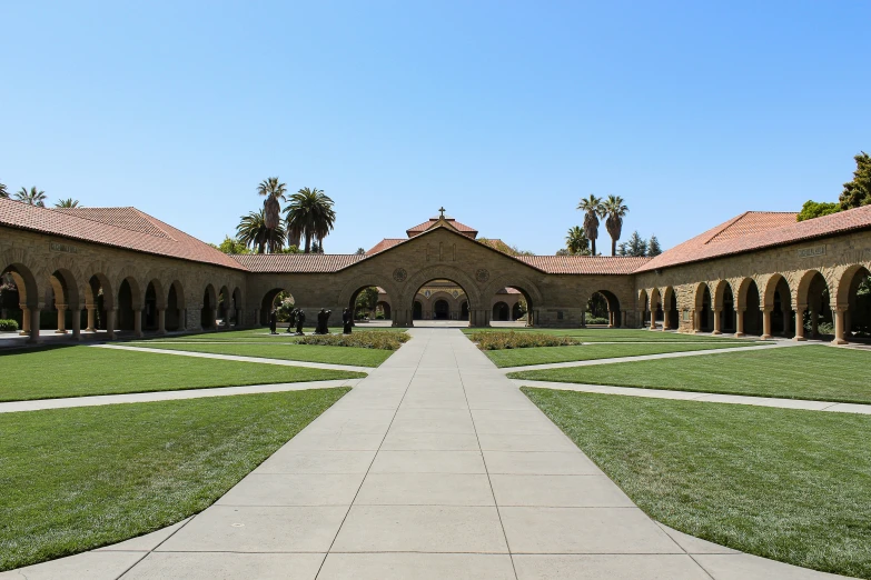 the walkway leads to a building surrounded by grass