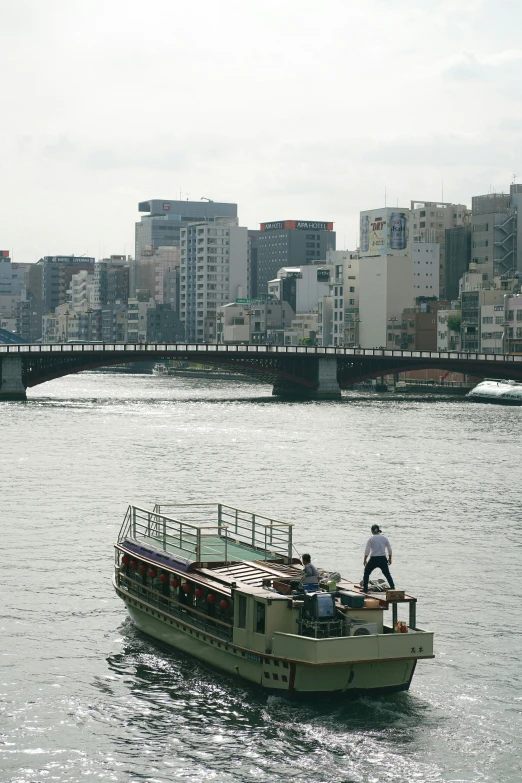 a man riding on the back of a long boat down a river