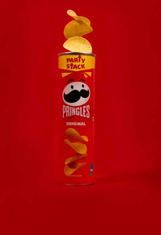 a can of pringles next to some chips