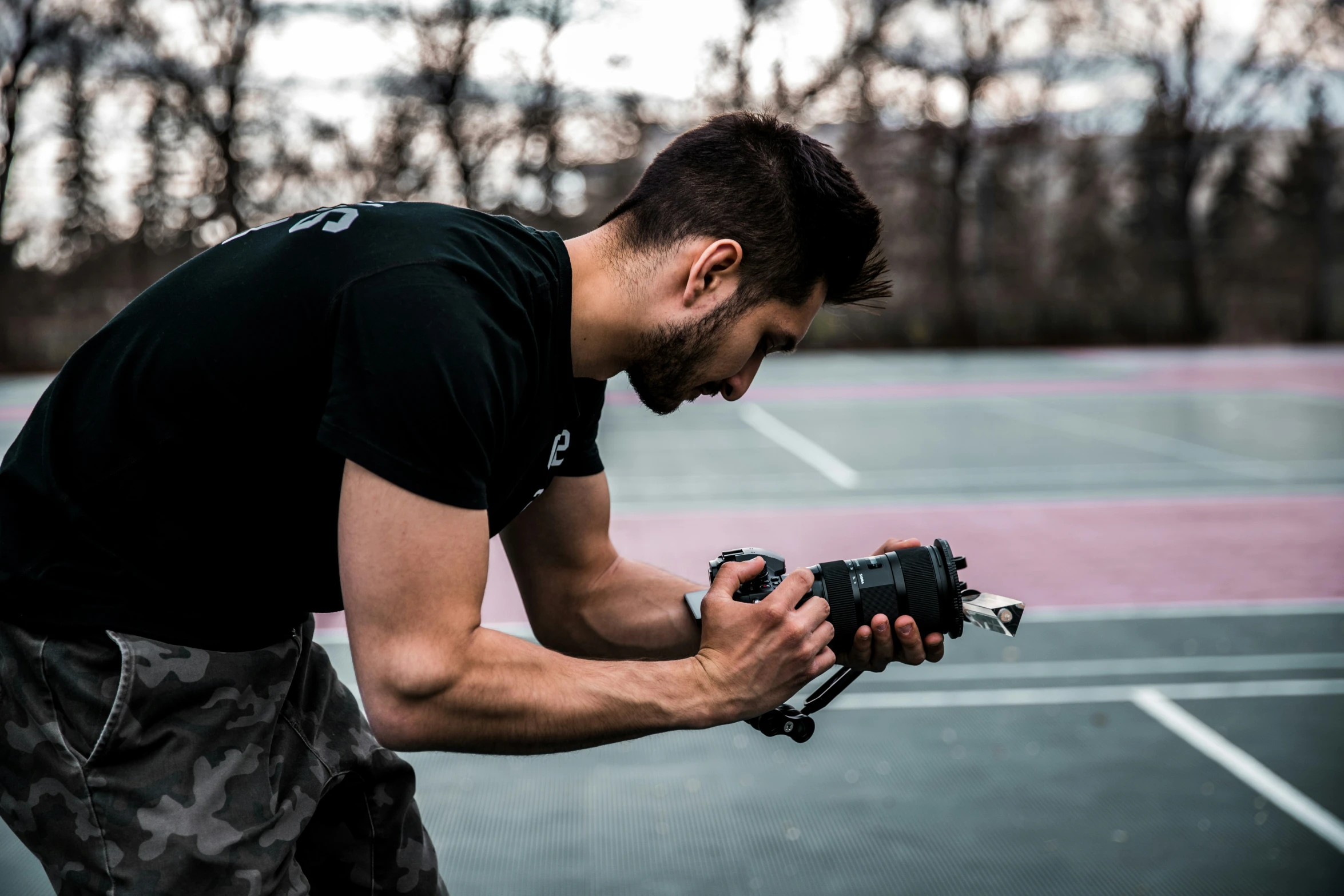 a man holds a camera on a court