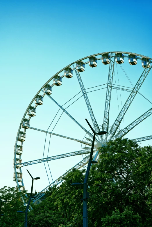 an old fashioned ferris wheel sitting behind some trees