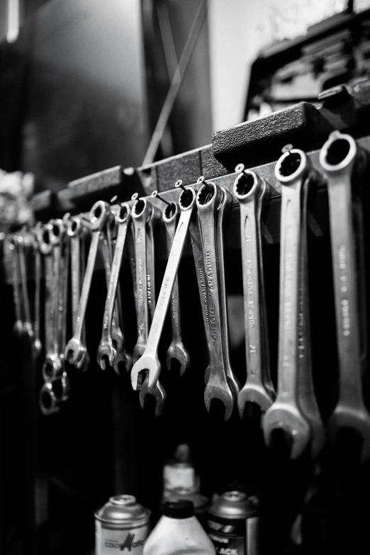 a black and white po with a bunch of wrenches hanging on the wall