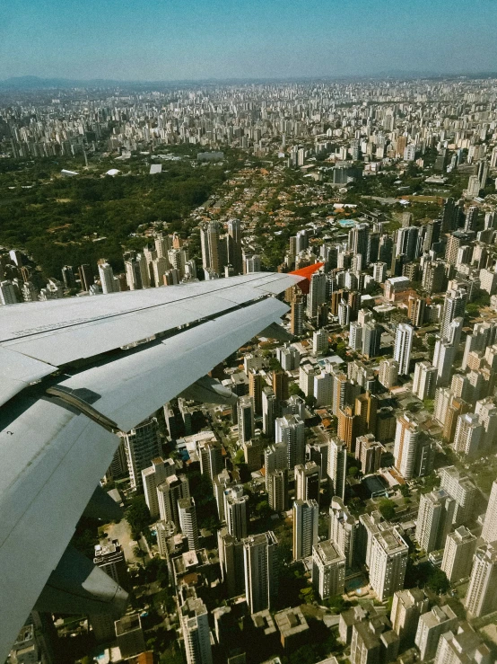 aerial view of an airplane wing over a city