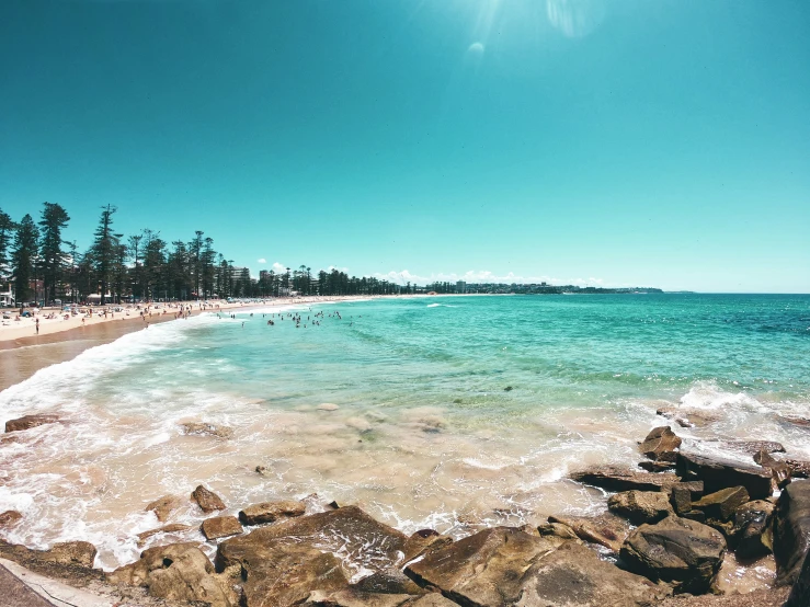 an image of a beach scene taken from the rocks