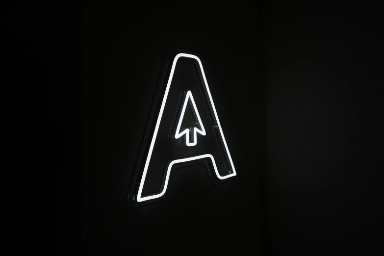 an illuminated sign on a black wall with no lighting