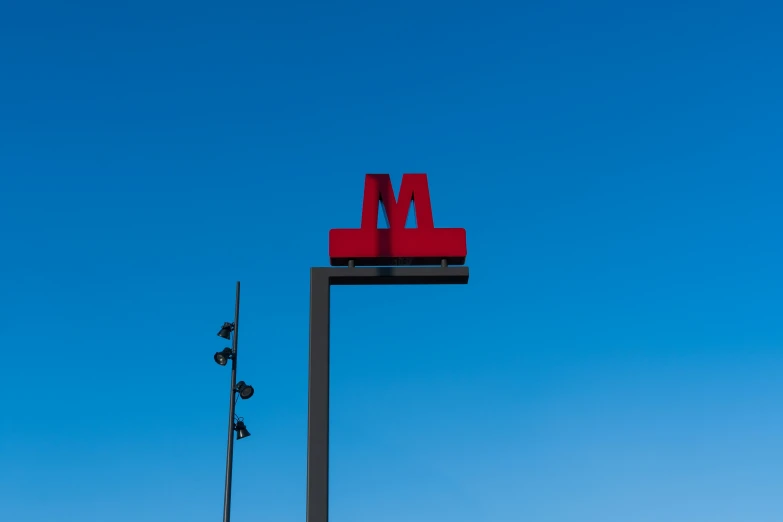 red m and m letters on a red sign with blue sky in the background