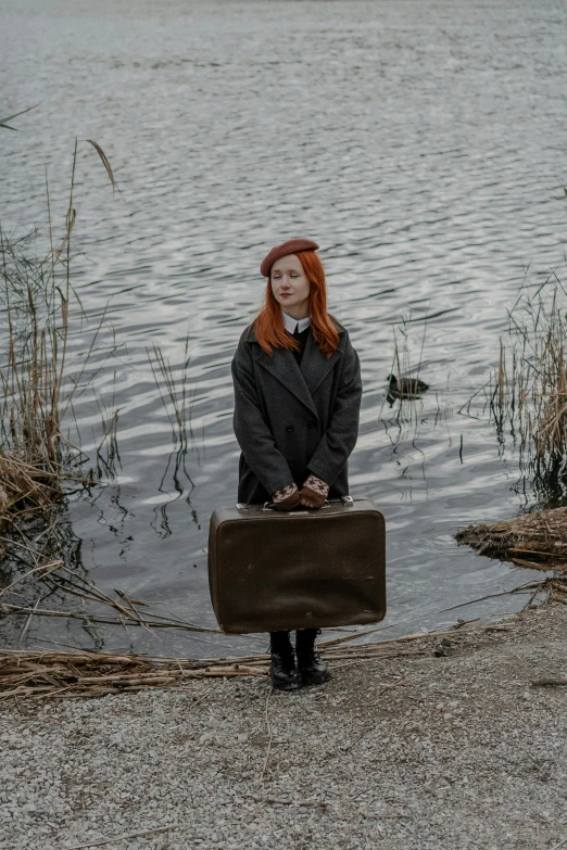 the woman is wearing black clothing and carrying a suitcase