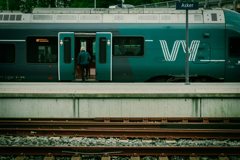 a train on a train track with a man boarding