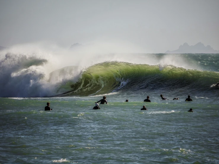surfers ride a giant wave in the ocean