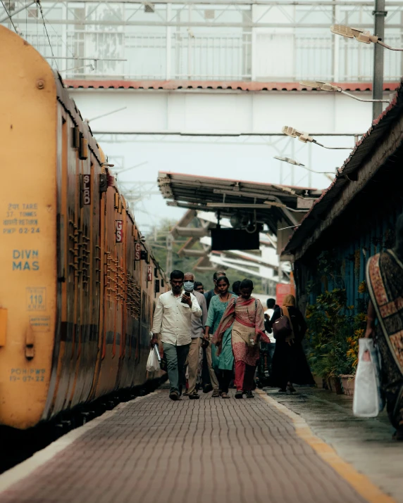 several people are waiting for the train at the train station