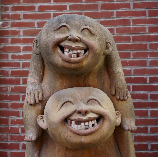 an image of a smiling statue holding another statue