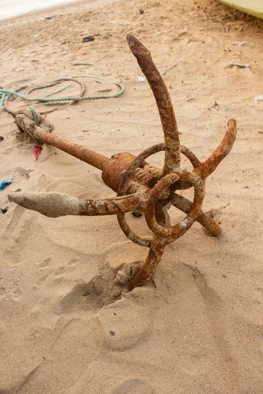 there is a rusty pipe sticking out of the sand