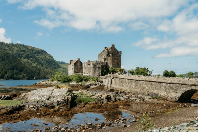 a castle sits on a rock formation near a body of water