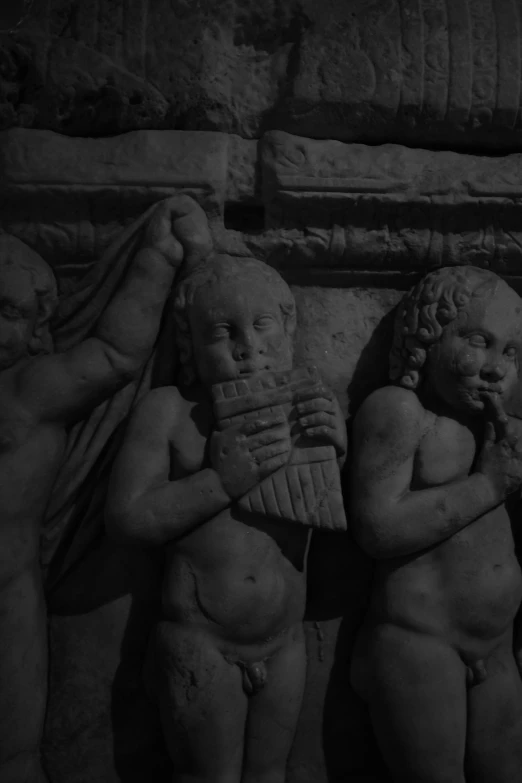 three ancient marble statues in a dark cave