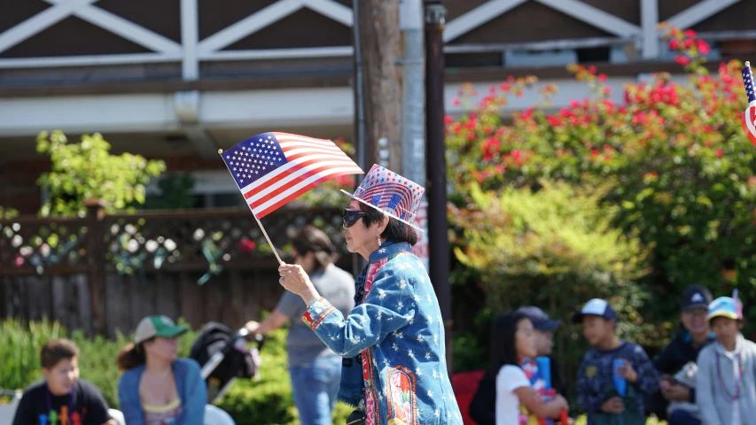 a woman with american flags is on the sidewalk