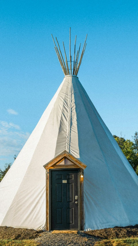 an old white teepee with a door