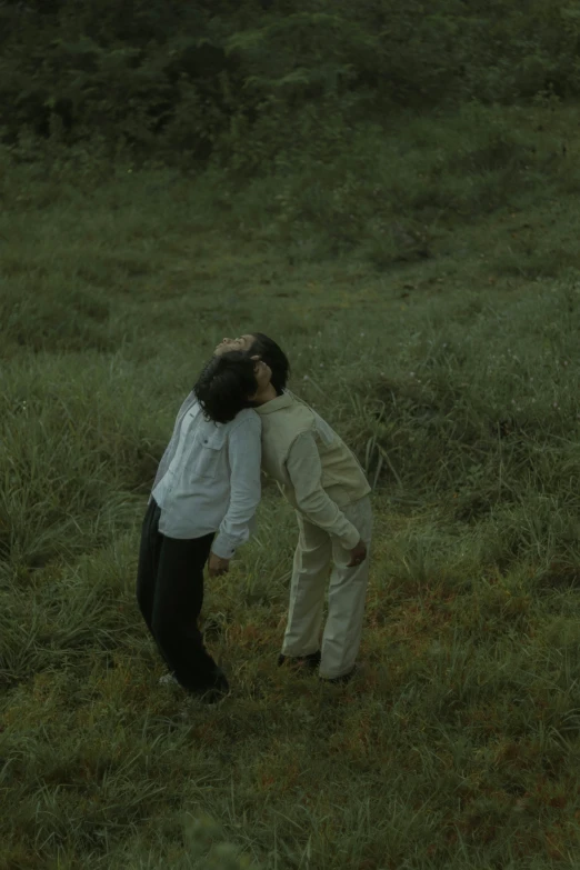 two people in a field touching noses and making faces