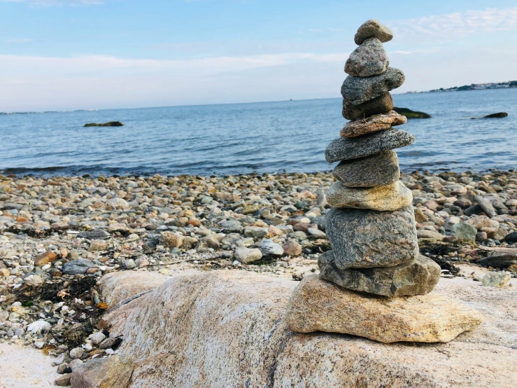 rocks stacked on each other in front of a body of water
