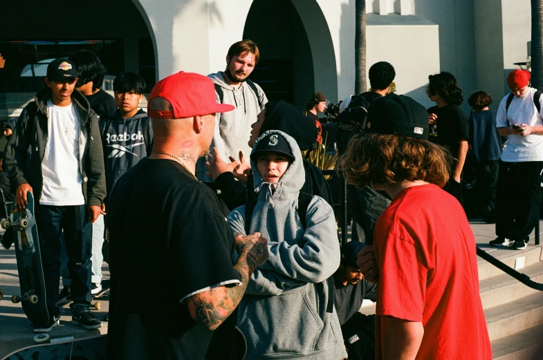 men standing outside a building on skateboards and talking