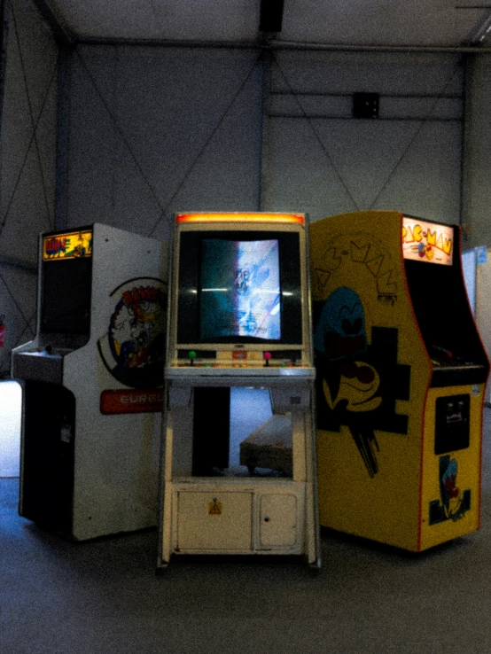 several old video game machines with a big screen monitor in a garage