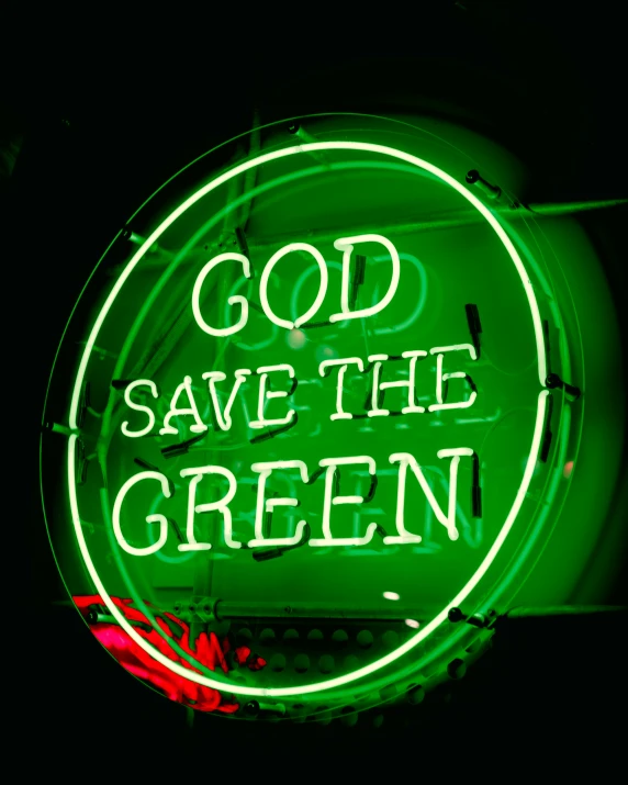 a neon green sign reading, god save the green