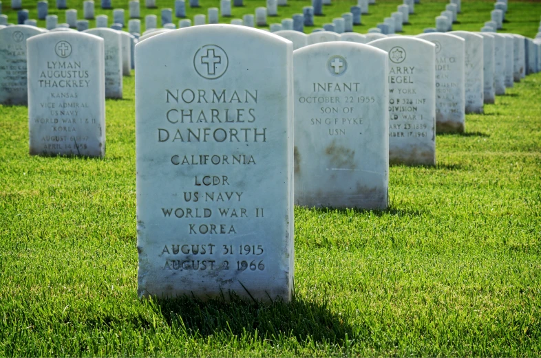 headstones in white stone on a green grass field