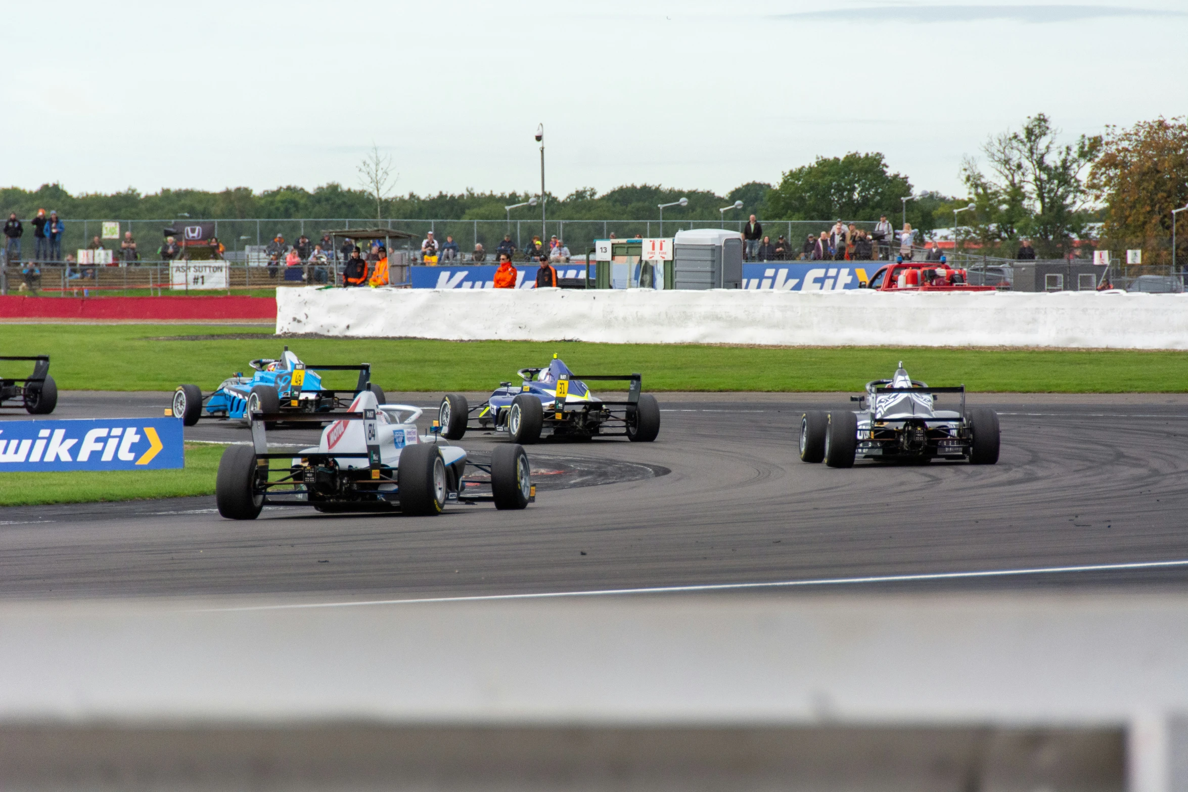 a group of men driving around a track