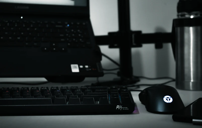 a computer keyboard and mouse next to a laptop