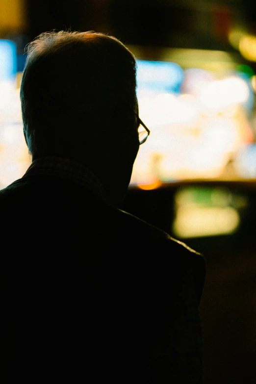 a man standing in the dark with his head tilted