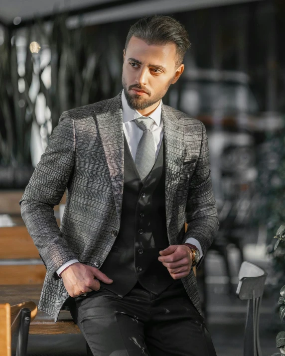 a man that is sitting on a bench wearing a suit