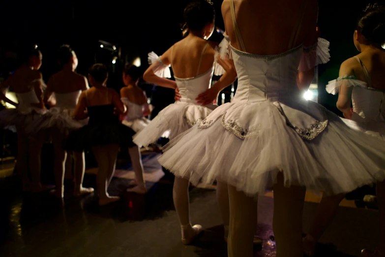 the women in white dresses are standing near each other