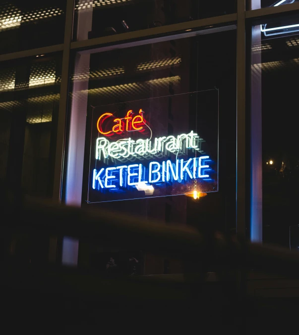 the neon sign for an outside restaurant at night